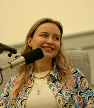 Frau mit Mikrofon lächelt.