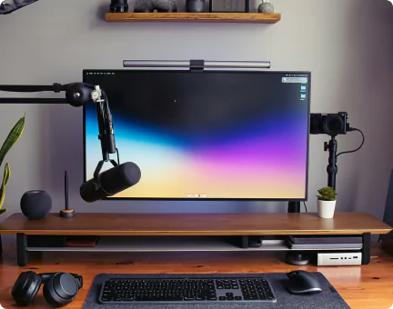 Moderner Schreibtisch mit Monitor und Mikrofon.