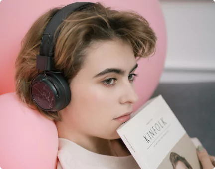 Frau mit Kopfhörern und Zeitschrift